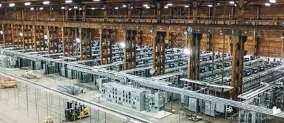 A sprawling mining farm illuminated by LED lights symbolizing large-scale hosting operations
